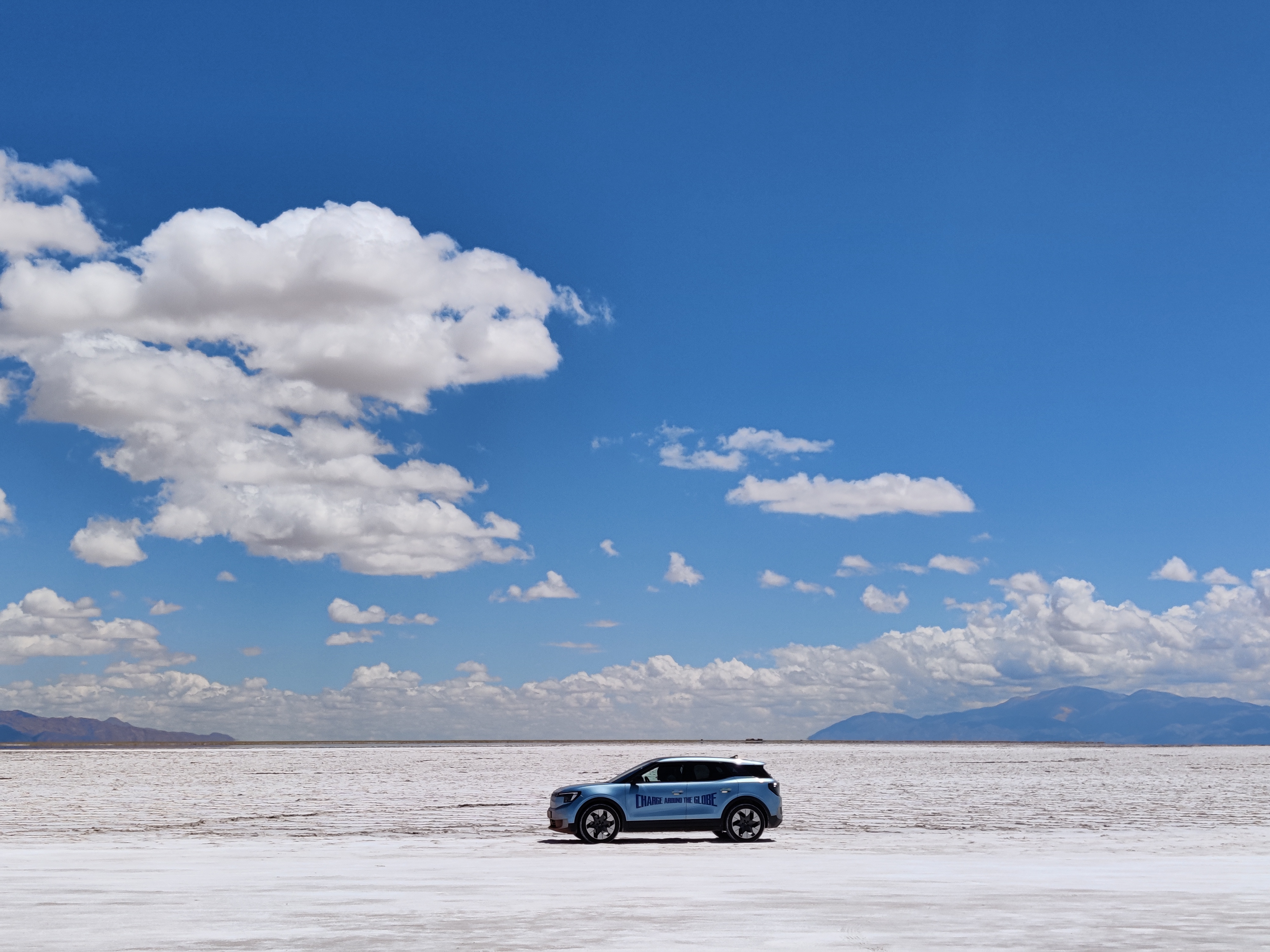 A blue car in vast white desert