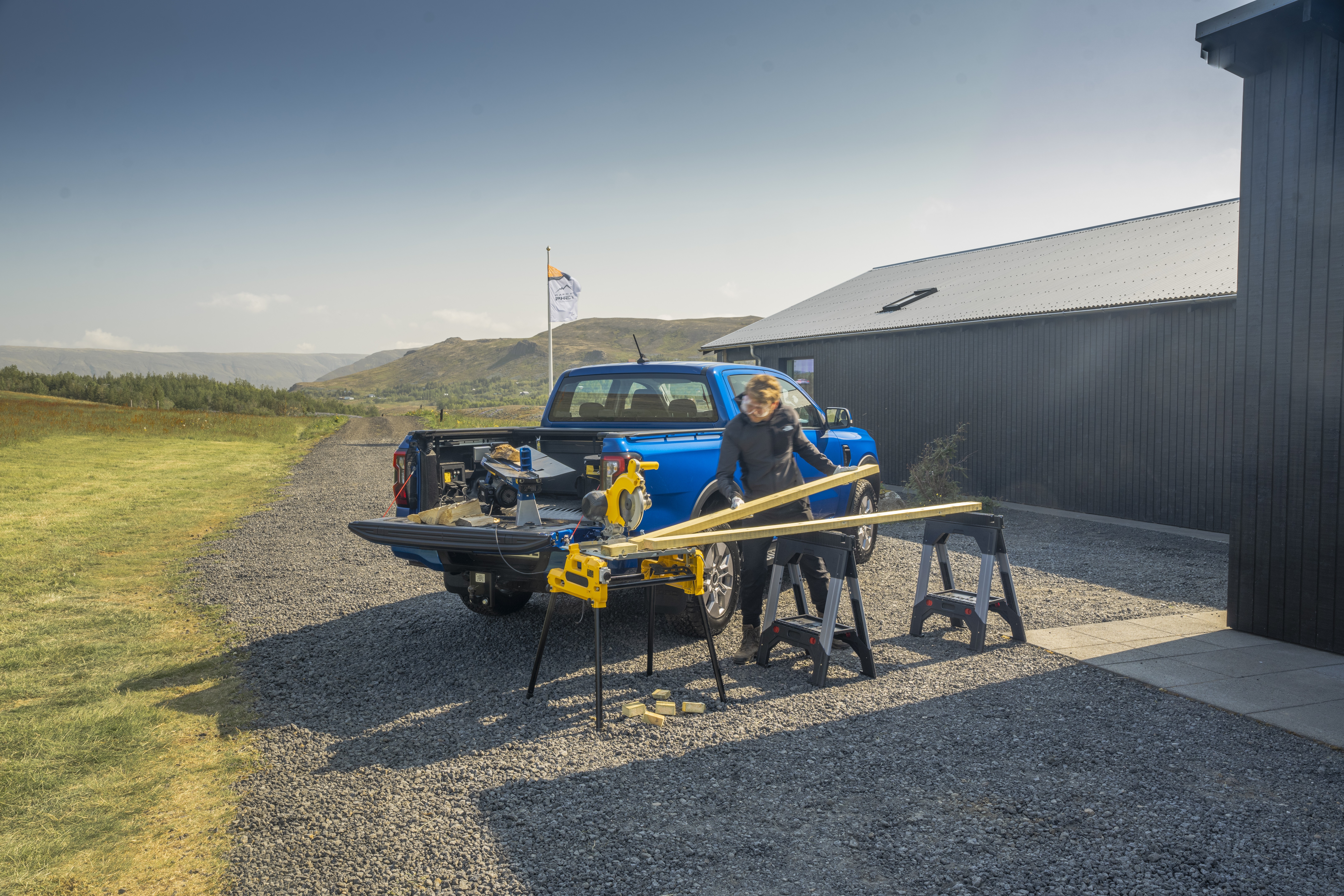 Ford Ranger PHEV Pro Power Onboard powers tools at a worksite. License valid for earned editorial, press releases, press kits. Region: Europe. This content is solely for editorial use and for providing individual users with information. Any storage in databases, or any distribution to third parties within the scope of commercial use, or for commercial use is permitted with written consent from Ford in Europe GmbH only.