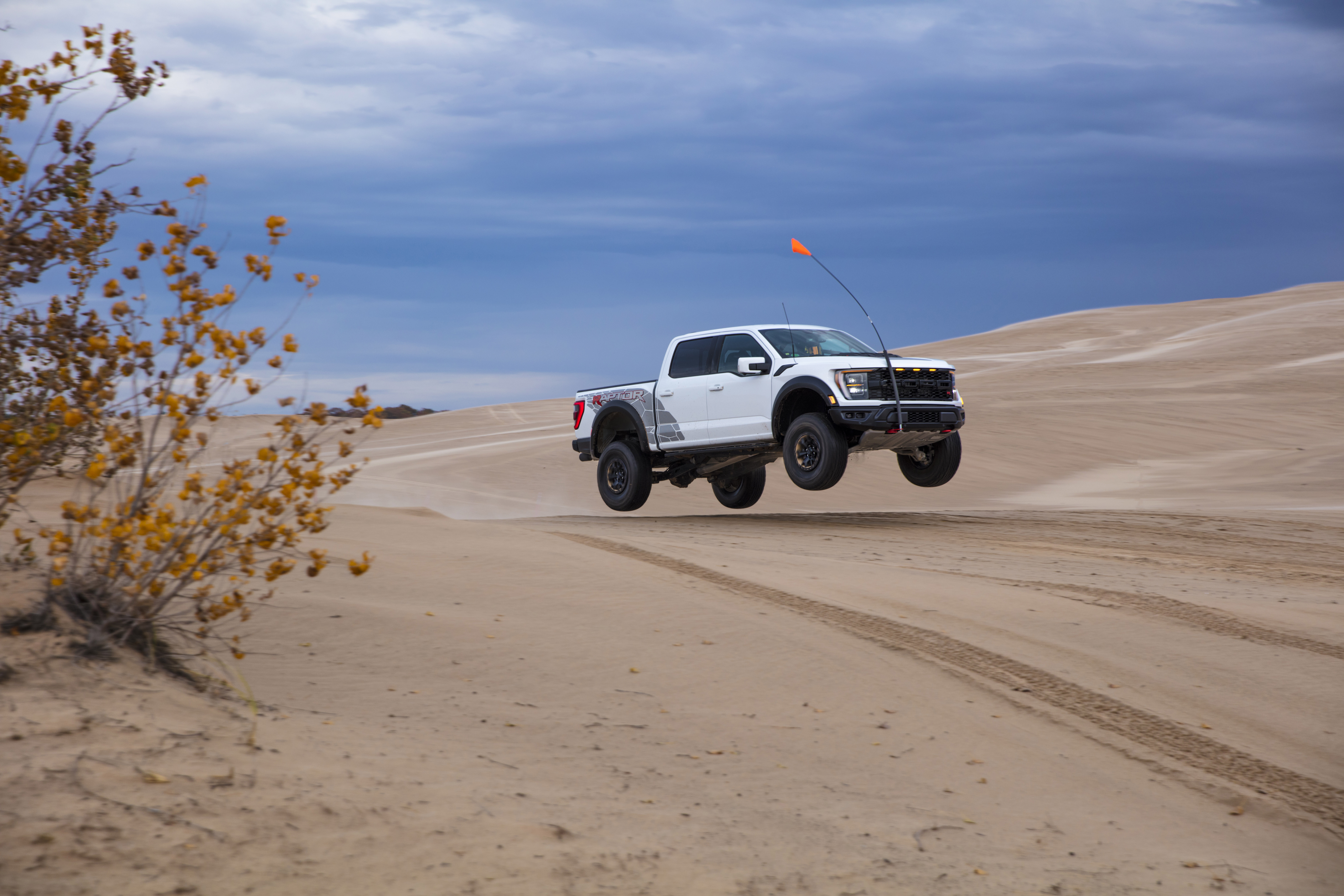 Preproduction 2023 F-150 Raptor R with aftermarket flag and optional equipment. Available late 2022. Professional driver on a closed course. Always consult the Raptor supplement to the Owner’s Manual before off-road driving, know your terrain and trail difficulty, and use appropriate safety gear. 