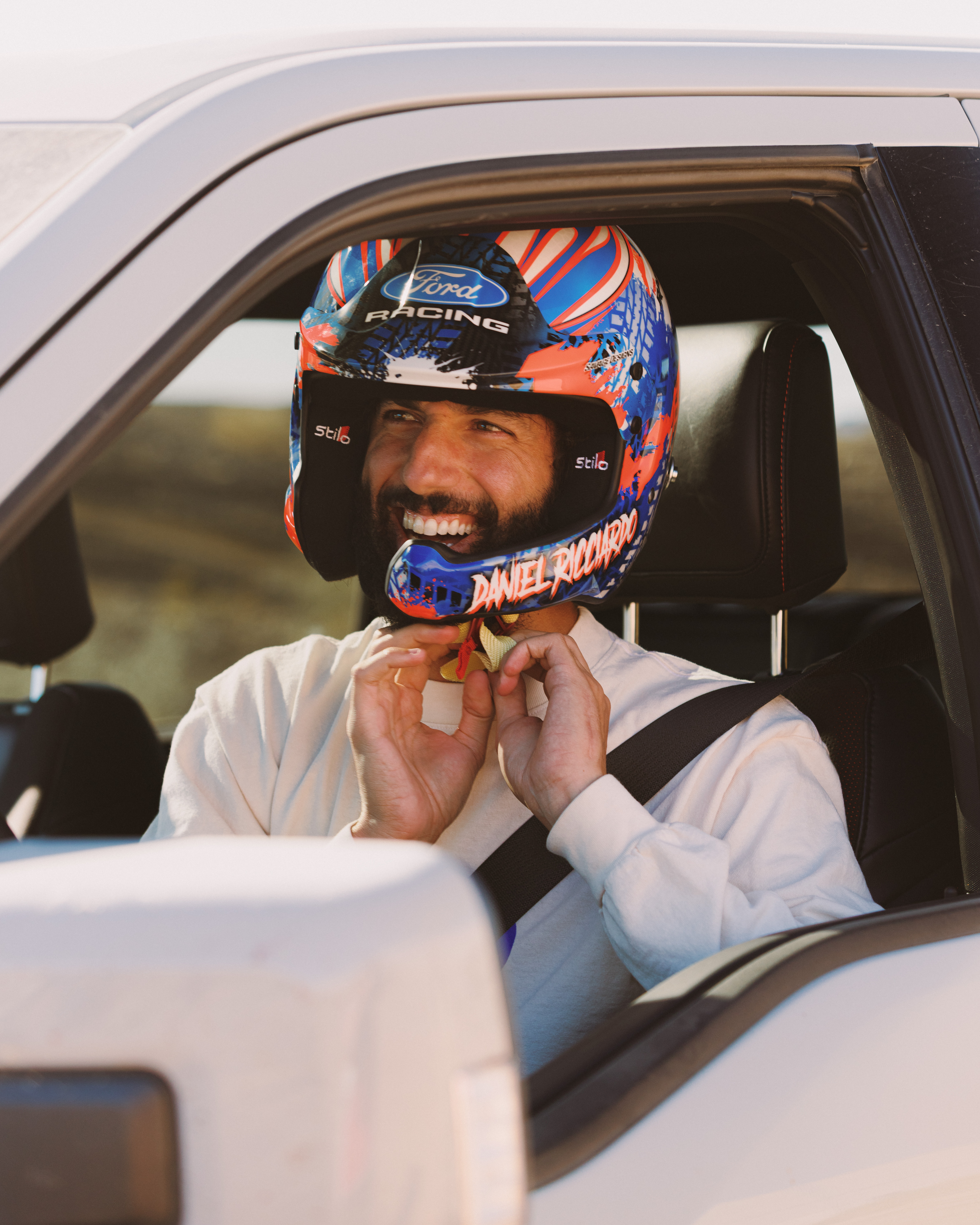 Daniel Ricciardo puts on his helmet as he prepares to drive his Raptor off-road.