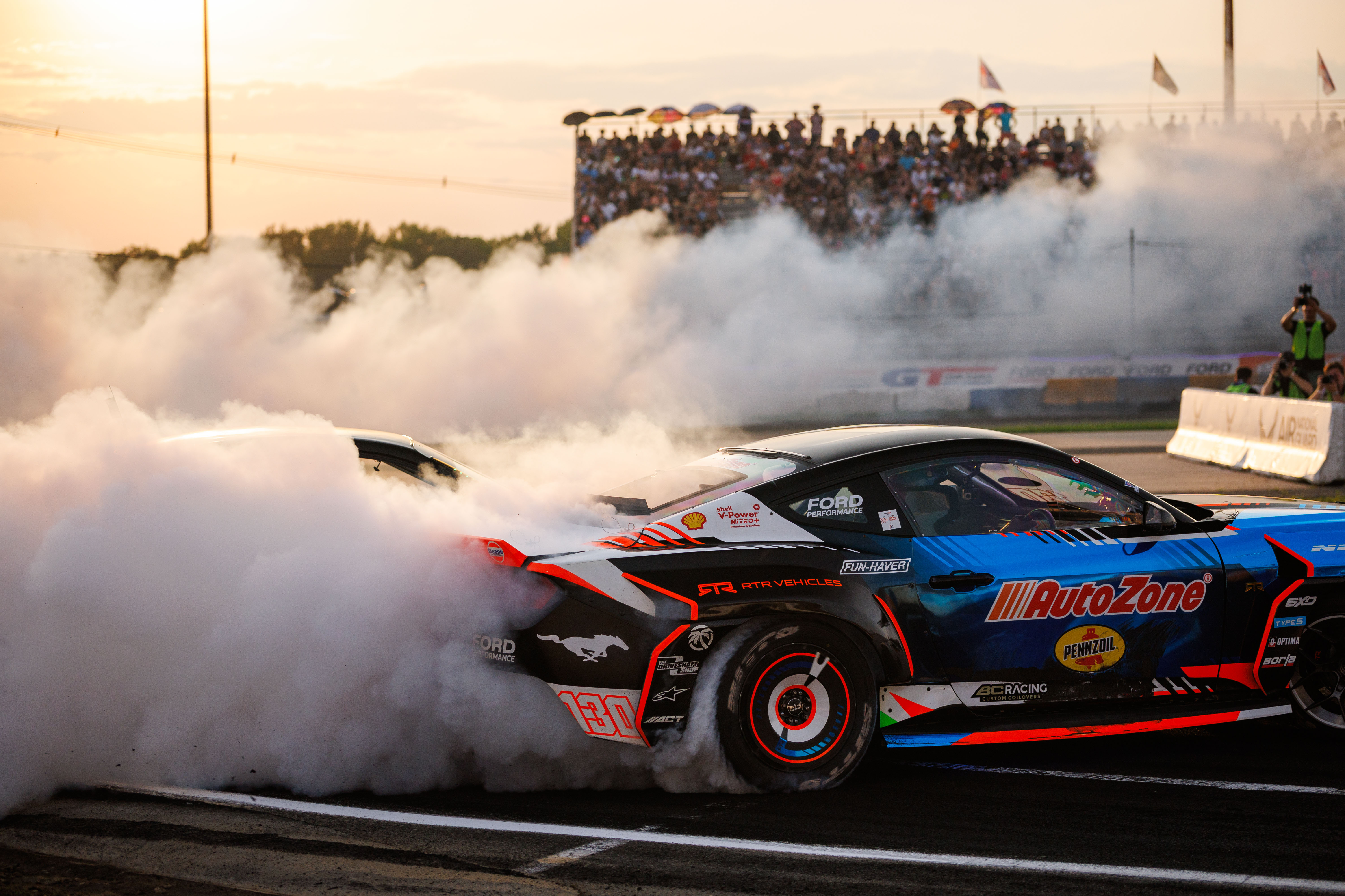 A Mustang drifts on a racetrack