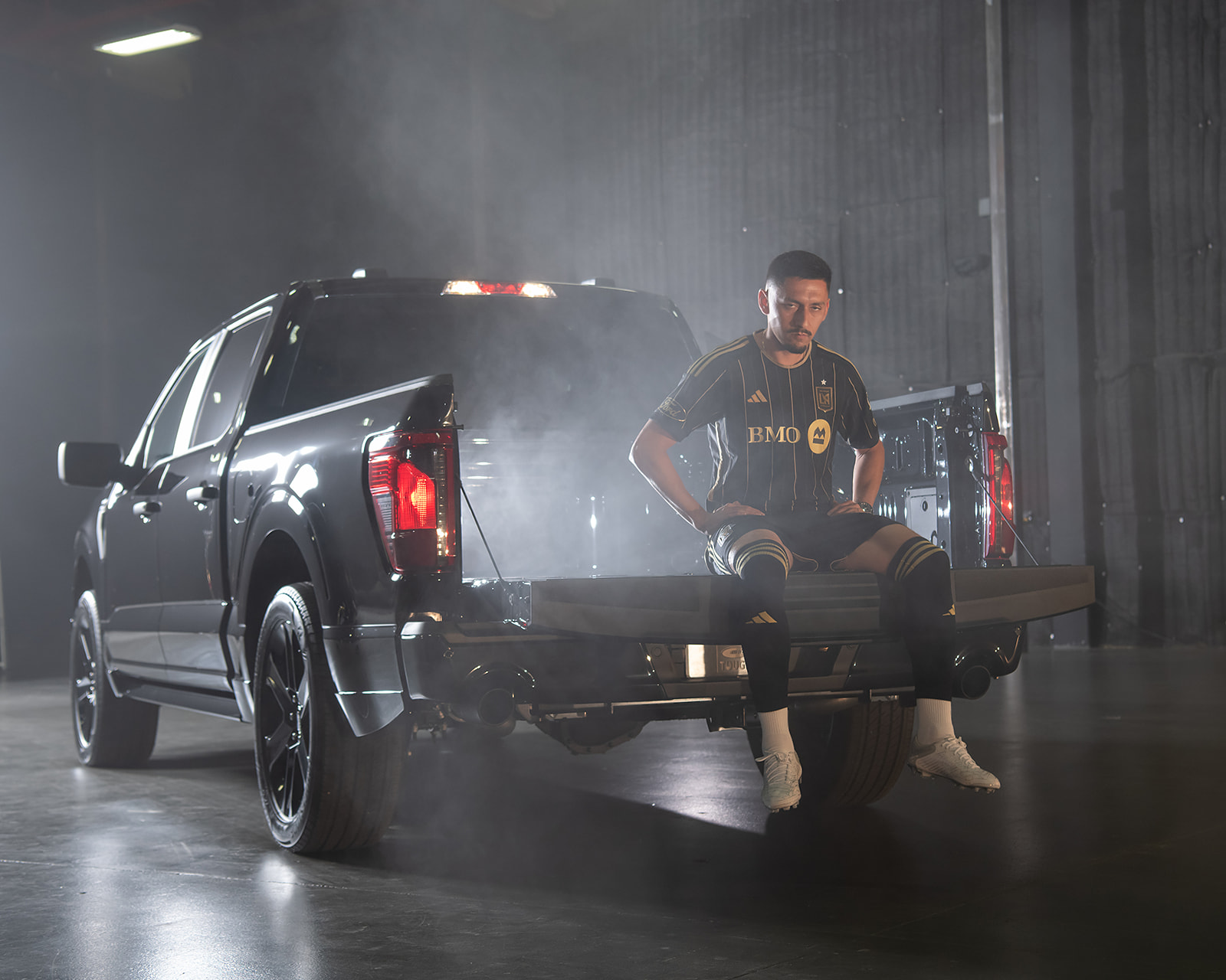 Los Angeles Football Club soccer player Mark Delgado rests on the open tailgate of the Ford F-150 Lobo.