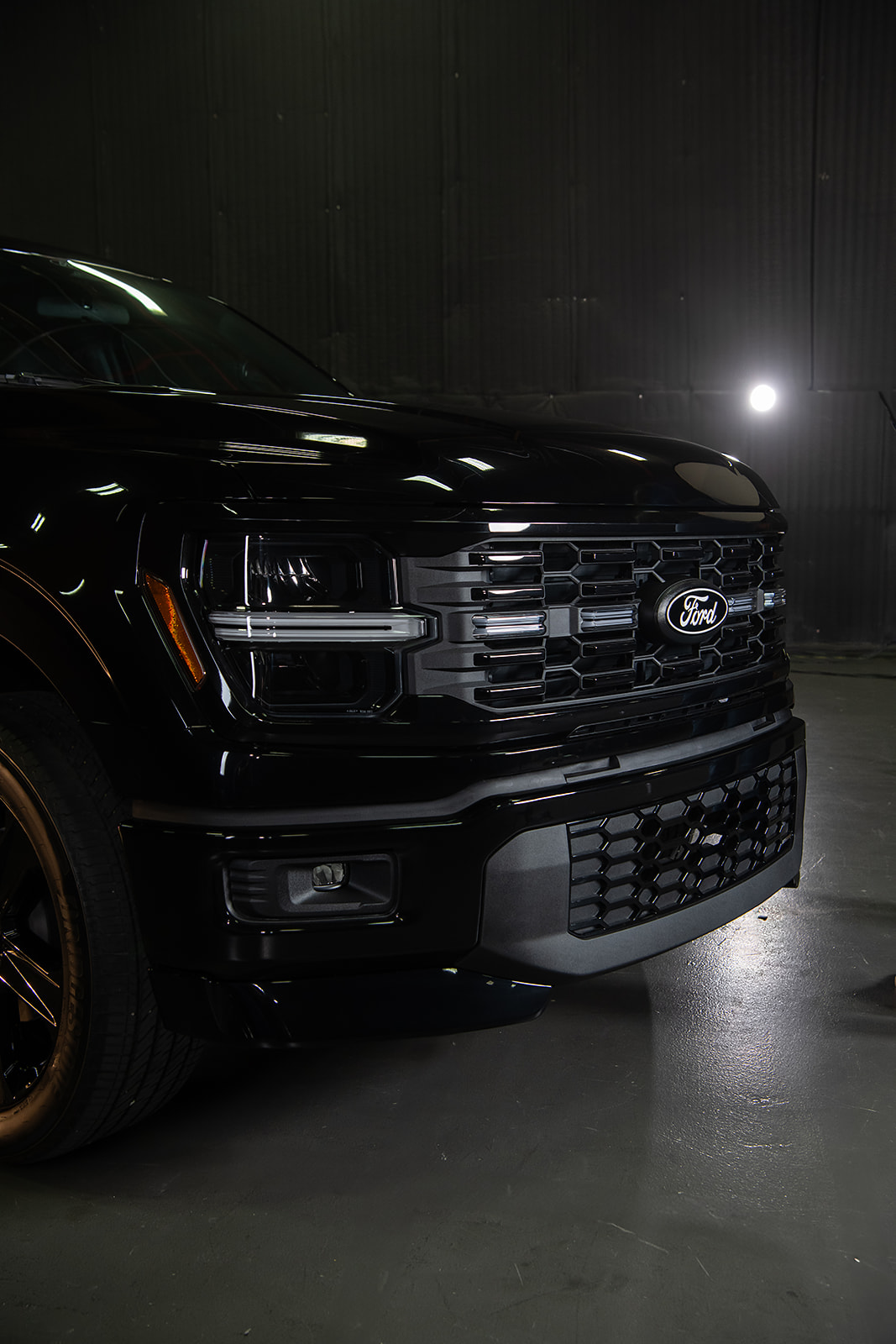 The grille of the new Ford F-150 Lobo shown in a dark room.