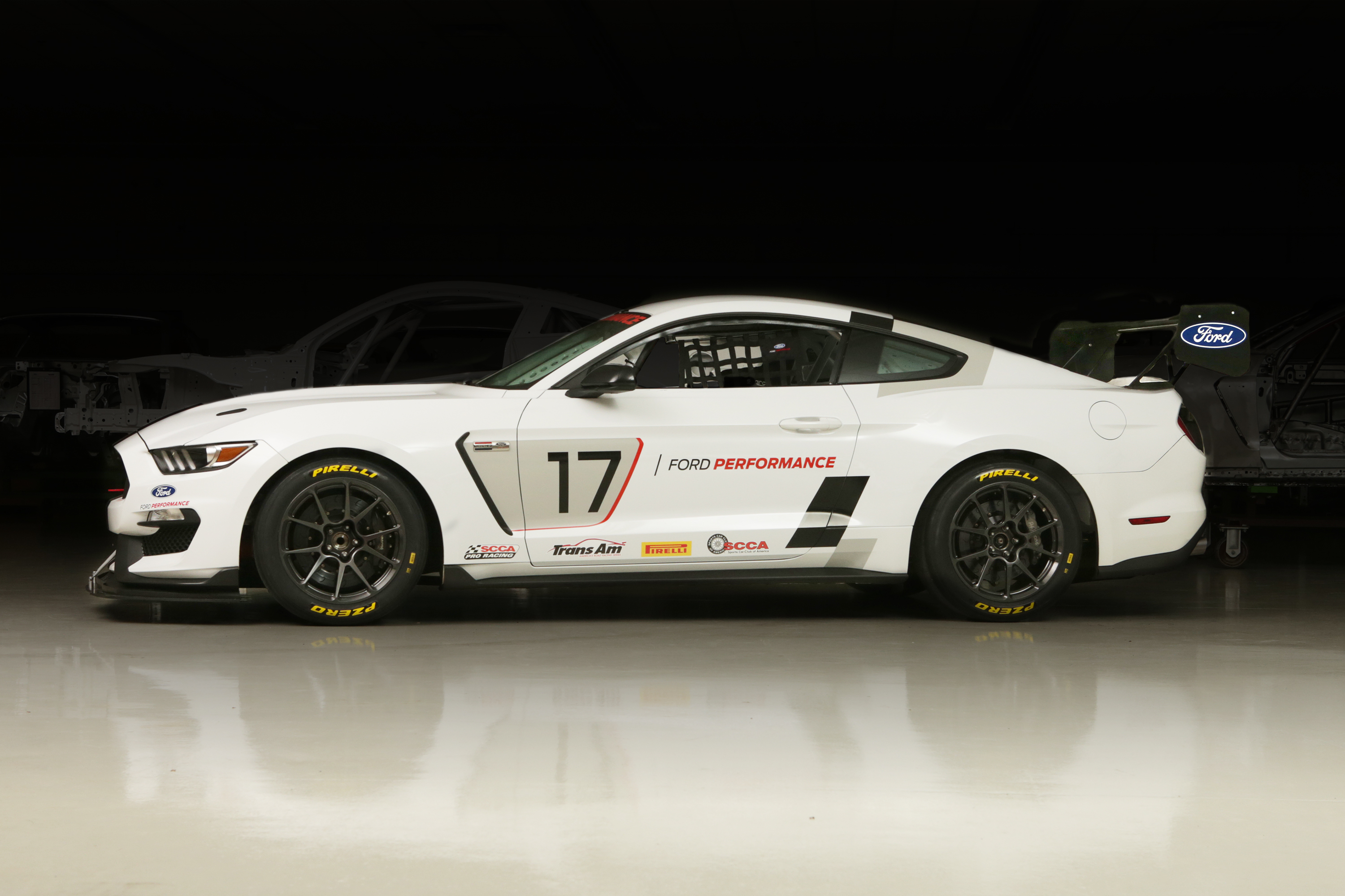 A white Mustang viewed from the side with the number 17 on it.