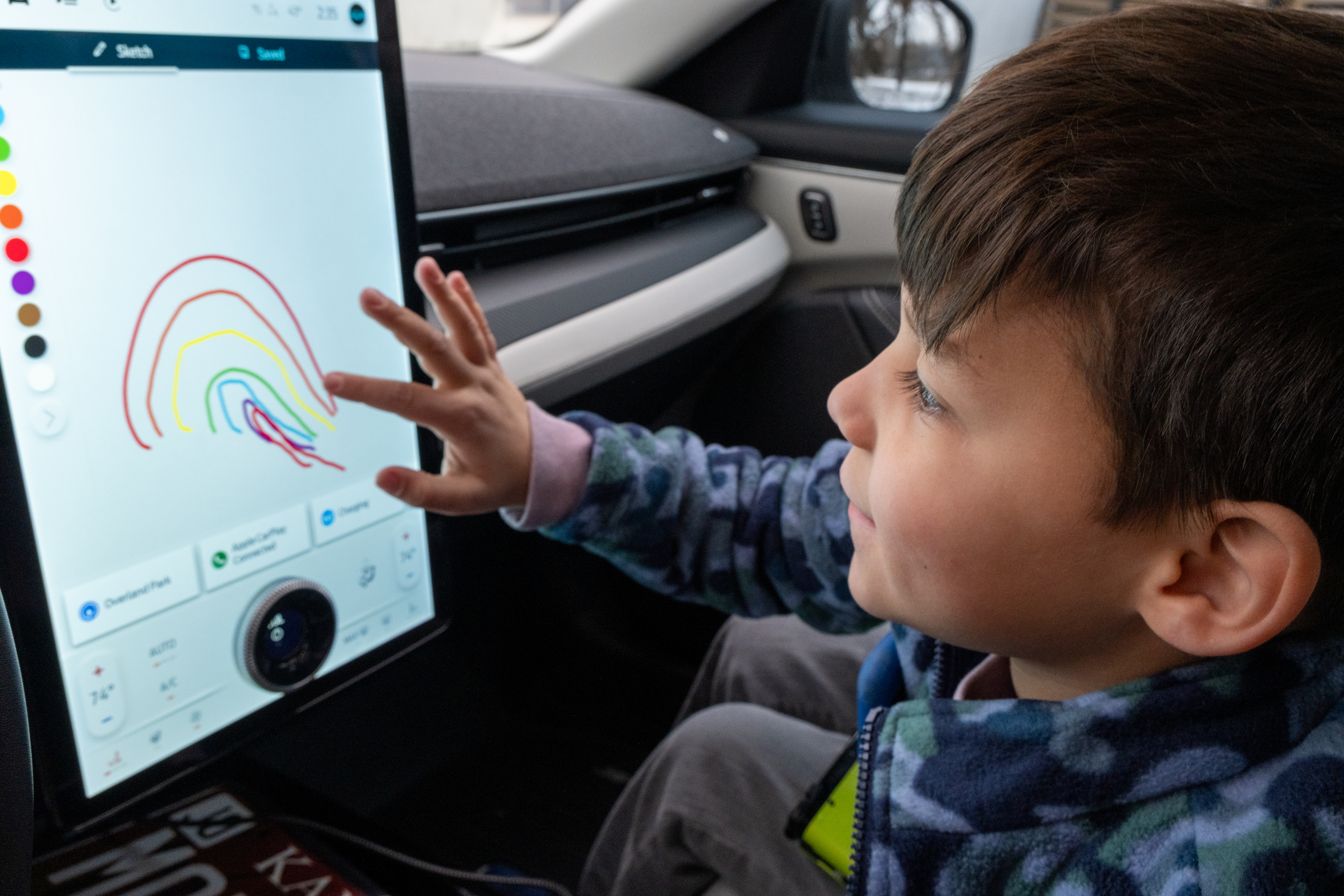 Oliver drawing a rainbow on the Mustang Mach-E's 15.5-inch touchscreen.